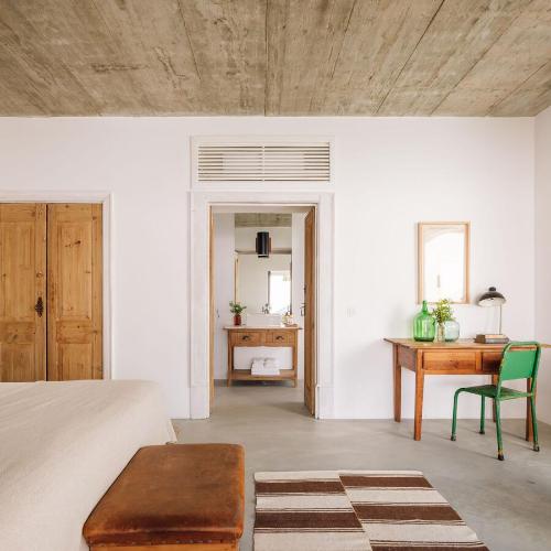 a living room with a table and a desk at Hospedaria in Cabanas de Tavira