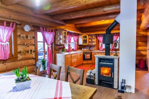 a kitchen with a stove and a dining room with a table at Chata Alexandra in Bobrovník