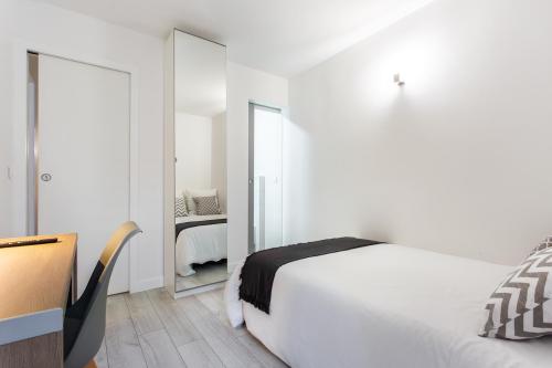 a white bedroom with a bed and a mirror at D&E - PARIS-DISNEY - HOLIDAYS APARTMENT - APPARTEMENT DE VACANCES - 5 CHAMBRES- 5 SDB - 5 BEDROOMS - 5 BATHROOMS - Netflix in Champs-Sur-Marne