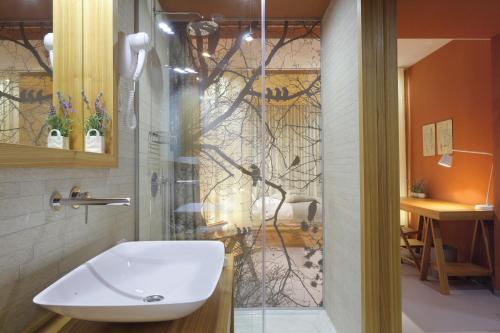 a bathroom with a sink and a glass shower door at Hotel Nox in Ljubljana
