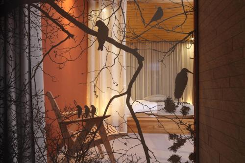 a group of birds sitting on a tree branch at Hotel Nox in Ljubljana