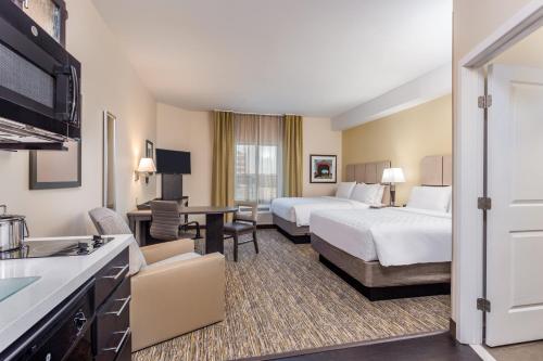 um quarto de hotel com duas camas e uma cozinha em Candlewood Suites Bethlehem South, an IHG Hotel em Bethlehem