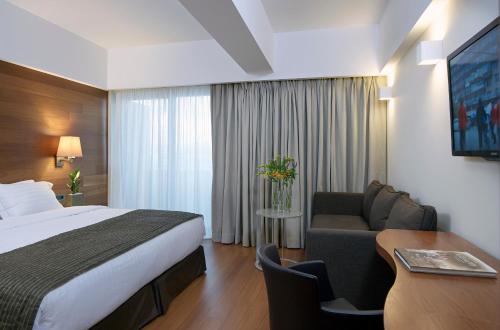 a hotel room with a bed and a desk at Samaria Hotel in Chania Town