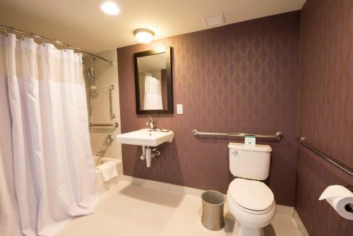 a bathroom with a toilet and a sink at Crowne Plaza Saddle Brook by IHG in Saddle Brook