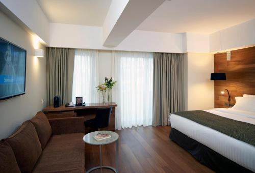 a hotel room with a bed and a couch and a desk at Samaria Hotel in Chania Town