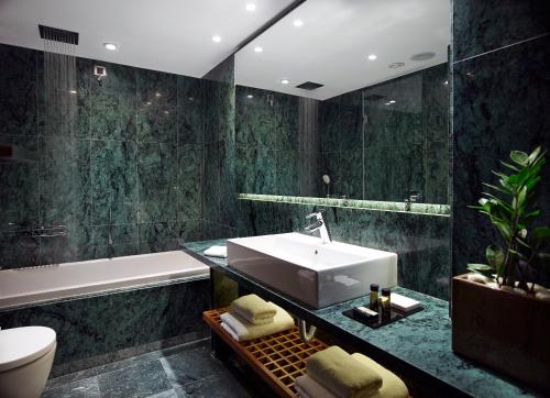 a bathroom with a sink and a bath tub at Samaria Hotel in Chania Town