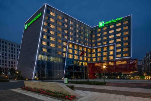 a tall building with a green sign on it at Holiday Inn Chengdu Airport by IHG - Free Shuttle to Shuangliu International Airport in Chengdu