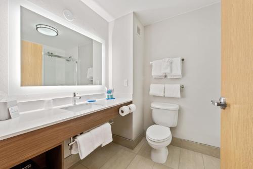 a bathroom with a toilet and a sink with a mirror at Holiday Inn Express West Valley City by IHG in West Valley City