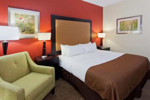 a hotel room with a bed and a chair at Holiday Inn Shreveport Downtown by IHG in Shreveport