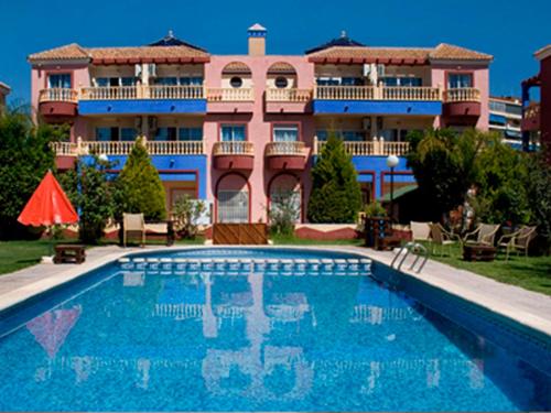 a house with a swimming pool in front of a building at Apartamentos Marina Internacional in Torrevieja