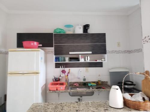 eine Küche mit Spüle und einem weißen Kühlschrank in der Unterkunft Apto. De frente pro Mar in Praia Grande