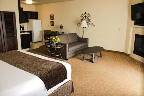 a hotel room with a bed and a couch at Oxford Suites Boise in Boise