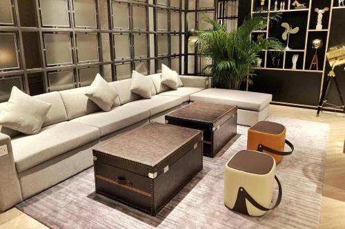 a living room with a couch and two ottomans at Livefortuna Hotel in Beijing