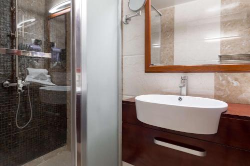 ein Badezimmer mit einem weißen Waschbecken und einer Dusche in der Unterkunft Best Western Plus Pearl Addis in Addis Abeba