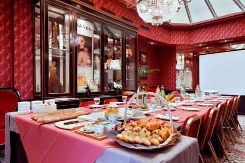 a long table with food on it in a restaurant at Grand Hotel de l'Opera - BW Premier Collection in Toulouse