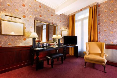 a room with a desk and a chair and a mirror at Grand Hotel de l'Opera - BW Premier Collection in Toulouse