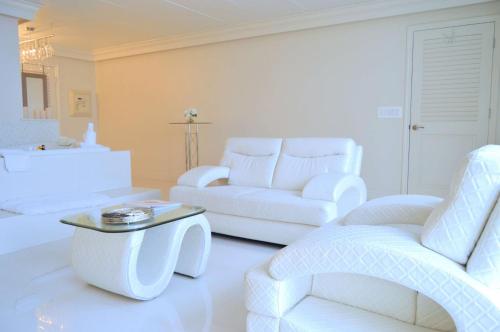 a white living room with two white couches and a table at Best Western Plus Wilkes Barre Center City in Wilkes-Barre