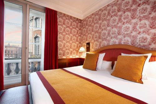 a hotel room with a bed and a window at Grand Hotel de l'Opera - BW Premier Collection in Toulouse