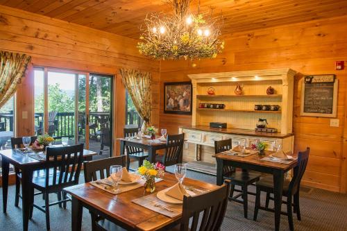 un comedor con mesas y sillas y una lámpara de araña en Lazy Bear Lodge, en Valle Crucis