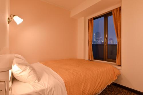 Postel nebo postele na pokoji v ubytování Kobe Sannomiya Union Hotel