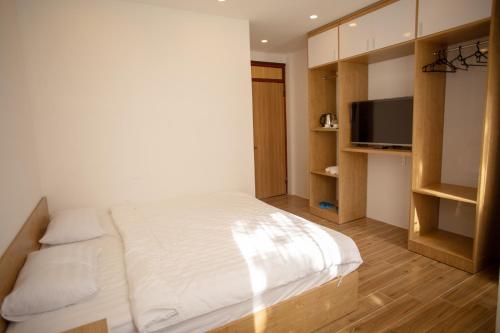 a bedroom with a large bed and a television at An Gia in Da Lat