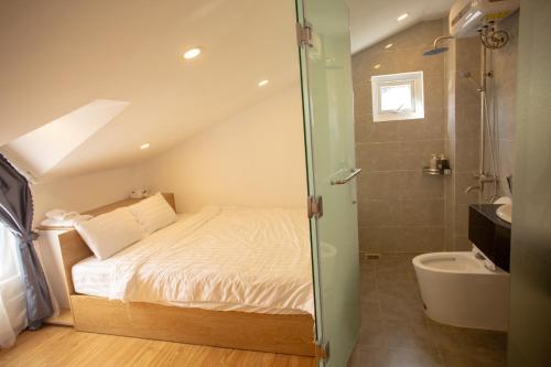 a small bedroom with a bed and a shower at An Gia in Da Lat