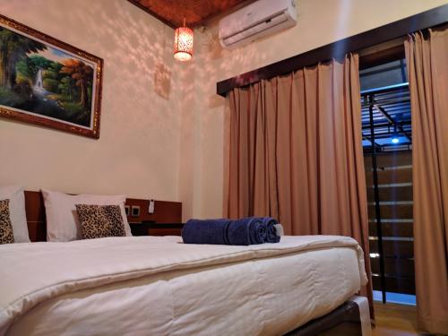 a bedroom with a bed and a window at Indah Nusantara in Banyuwangi
