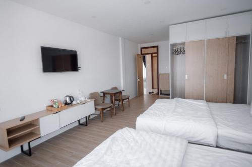 a bedroom with a bed and a desk and a tv at An Gia in Da Lat