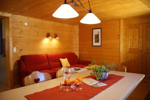 ein Wohnzimmer mit einem roten Sofa und einem Tisch in der Unterkunft Haus Gstüat in Lech am Arlberg