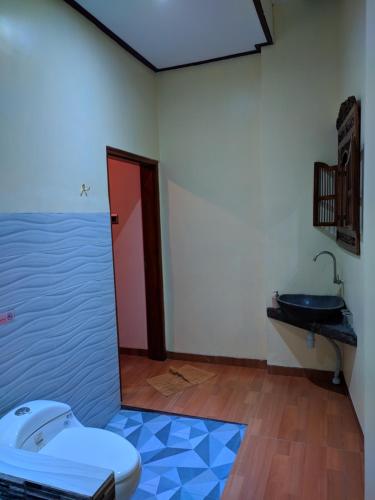a bathroom with a toilet and a sink at Indah Nusantara in Banyuwangi