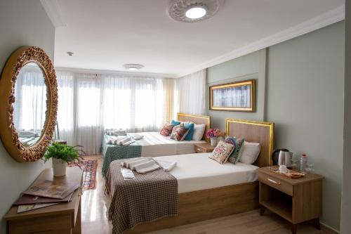 una camera da letto con due letti e uno specchio di Sofia Corner Hotel a Istanbul