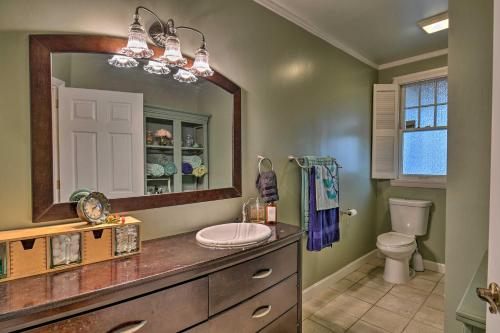 Un baño con lavabo, espejo e inodoro. en 2 Mi to Oaklawn Casino Home with Peaceful Yard!, en Hot Springs