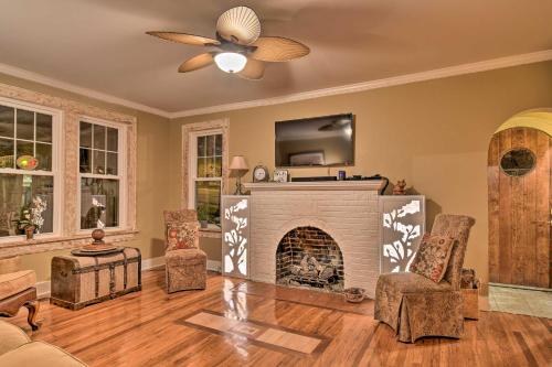 a living room with a fireplace and a ceiling fan at 2 Mi to Oaklawn Casino Home with Peaceful Yard! in Hot Springs