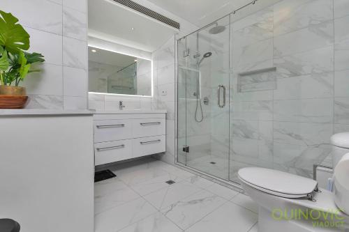 オークランドにあるQV Glamour 2 Bedroom Apt with Carpark - 758のシャワーとトイレ付きの白いバスルーム