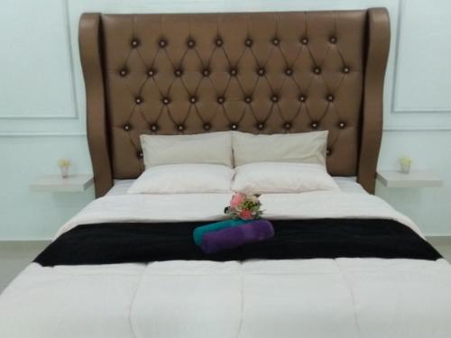 a bed with white sheets and a brown headboard at Captain's Cabin Resort - Naval Heritage (Swimming Pool) in Kota Bharu