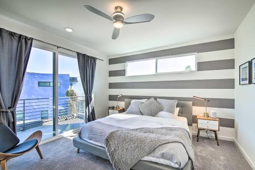 Dormitorio con paredes a rayas, cama y ventana en Modern Oasis with Mtn-View Pool Deck - Walk Downtown en Palm Springs