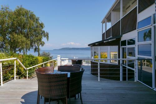 a balcony of a house with a table and chairs at VU Thermal Lodge - ADULTS ONLY MOTEL in Taupo