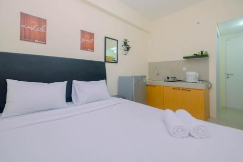 a bedroom with a large white bed and a sink at Comfy Studio Bogorienze Apartment near The Jungle Fest By Travelio in Bogor