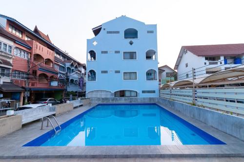 a building with a swimming pool in front of a building at Thipurai Annex Hotel in Hua Hin