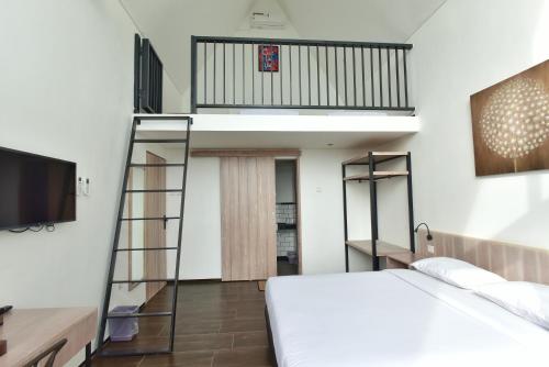 a bedroom with a bed and a tv and a ladder at Negla Beach Villa in Godog