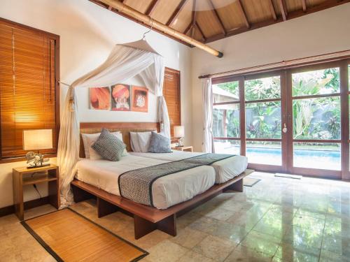 ein Schlafzimmer mit einem Himmelbett in der Unterkunft Mango Tree Villas in Jimbaran