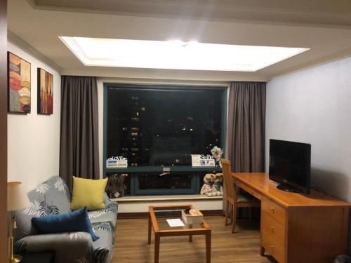 a living room with a window and a couch and a television at Luxury House in Taichung