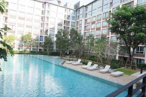 a swimming pool in front of a large building at Cozy room close to Central Festival in Chiangmai in Chiang Mai