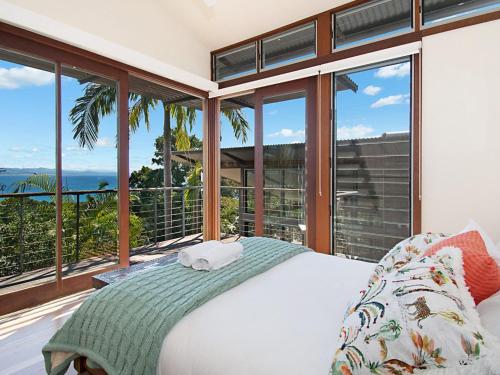 a bedroom with a bed with a view of the ocean at Above The Pass in Byron Bay