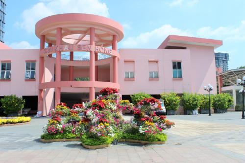 un edificio rosa con flores delante en Liberty Hotel Saigon Greenview en Ho Chi Minh
