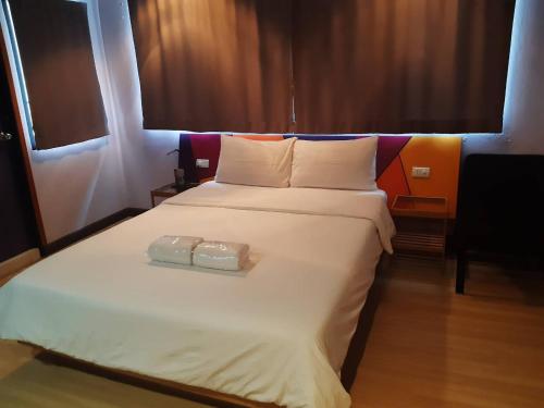 a hotel room with a bed, desk, and nightstand at Room@Vipa in Bangkok