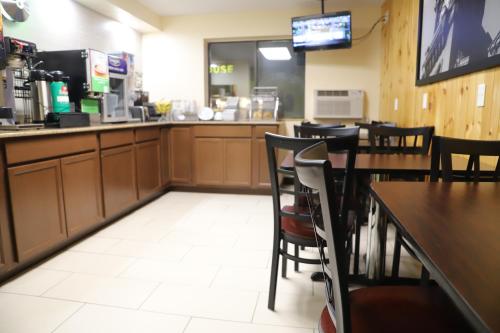 a restaurant with tables and chairs and a counter at Super 8 by Wyndham Richmond Airport VA in Richmond