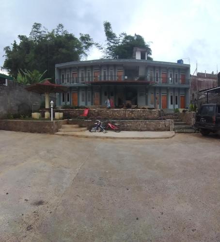 a house with a motorcycle parked in front of it at Hazza syaria homestay in Garut