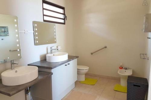 a bathroom with two sinks and a toilet at Villa Tiarenui in Maharepa