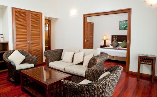 a living room with a couch and chairs and a bed at The Naviti Resort in Korolevu